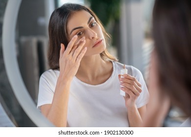 Beauty routine. A woman appying a concealer to her skin
