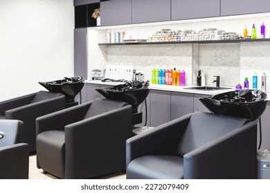 Beauty salon barbershop interior. Large comfortable black leather armchairs in a modern, cozy and bright room.