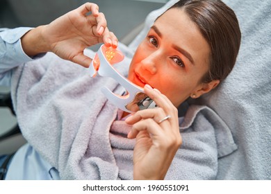 Beauty Salon Customer Putting On The LED Light Therapy Eyeglasses