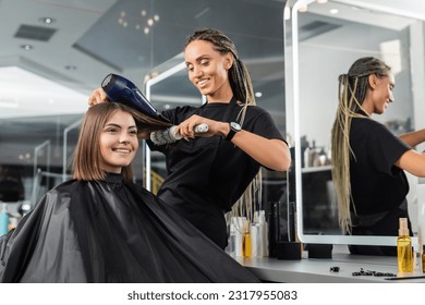 beauty salon, professional beauty worker with round brush and hair dryer styling hair of happy customer, brunette woman with short hair, salon blow dry, client satisfaction, hair volume - Powered by Shutterstock