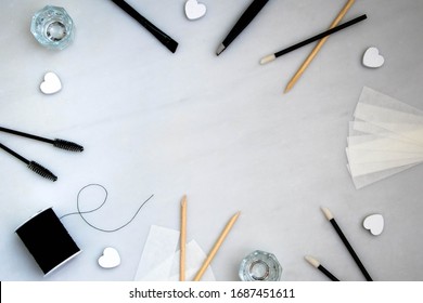 Beauty salon tools and equipment in a flat lay style on a white marble background with space for text and customization