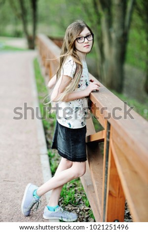 Similar – Junge Frau sitzt auf einer Bank in einem Park in ruhiger Pose.