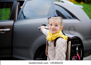 Beauty School Aged Kid Girl In Glasses And Yellow Scarf Near The Car