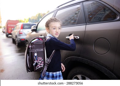 Beauty School Aged Kid Girl In Glasses And Uniform Near The Car