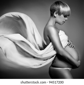 Beauty and sexy of young pregnant woman with blowing white material - grey background