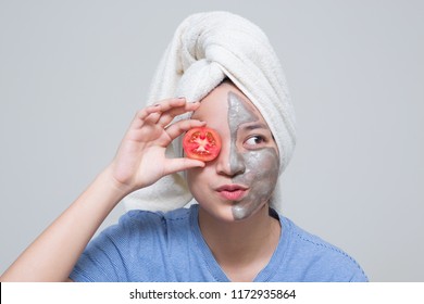 Beauty Shot Of Asian Cute Girl With Beautiful Skin Shows Mask Cream On Her Face And Holding Tomato Or Cucumber As Nutrient For Treatment Her Facial Skin