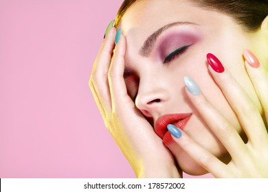 Beauty shot of model wearing colorful nail polish on pink