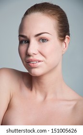 Beauty Shot In Studio Of Young Happy Pretty Smiling Woman Model With Toothy Smile, Natural Makeup, Clear Skin, Hair Pulled Back, Looking At Camera Gray Background, Copy Space