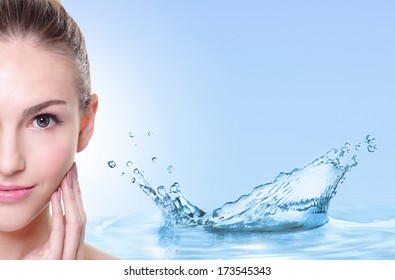Beauty Skin care concept, Beautiful woman face with Water splashes isolated on blue background