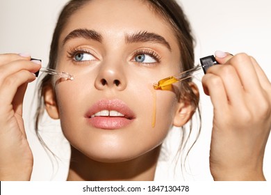 Beauty and skin care concept. Face of woman applying tea tree and lemon facial C-Serum, using anti-aging treatment products, hydrating and nourishing skin for better tone.