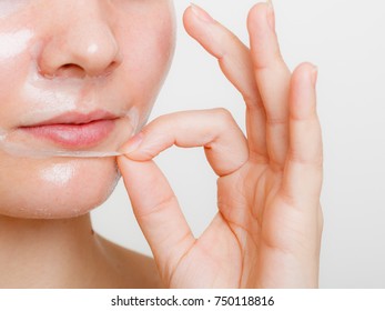 Beauty Skin Care Cosmetics And Health Concept. Young Woman Face, Girl Removing Facial Peel Off Mask. Peeling.