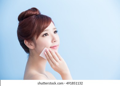 beauty skin care woman smile and make up on her face isolated on blue background, asian