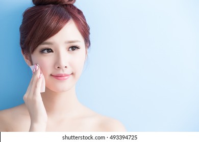 beauty skin care woman smile and make up on her face isolated on blue background, asian