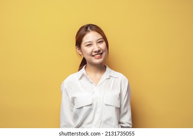 Beauty And Skincare. Close Up Of Young Asian Woman , No Make Up Skin And Smiling, Standing In White Shirt Against Yellow Background.