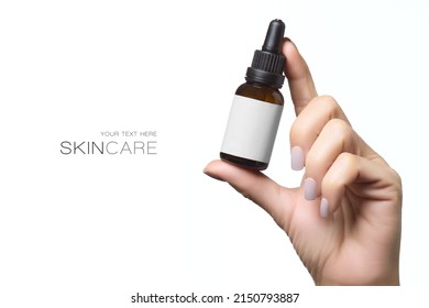 Beauty and skincare concept. Woman's hand holding a glass cosmetic bottle with empty label for your design. Isolated on white background with copy space - Shutterstock ID 2150793887