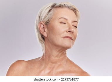 Beauty, skincare and face of a senior woman posing with closed eyes and topless against grey studio background. Happy old, elderly or mature female with glowing skin due to cosmetic self care - Powered by Shutterstock