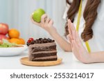 Beauty slim female body confuse chocolate cake. Woman in restaurant achieves weight loss goal for healthy life, crazy about thinness, thin waist, nutritionist. Diet, body shape.