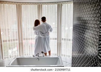 Beauty, Spa, Healthy Lifestyle Concept. Beautiful Young Couple In Bathrobes Relaxing At Luxury Hotel Room. The Boy And The Girl Are Resting In A Cozy Place And Drinking Wine. Wellness Theme