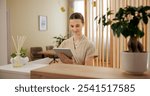 Beauty, spa and woman at front desk with tablet checking website for online appointment booking. Consultant, receptionist or girl at reception with digital app for schedule plan at luxury hotel salon