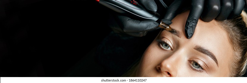 Beauty specialist doing eyebrow powder permanent makeup on a female brows. Space for text. Negative space - Shutterstock ID 1864110247