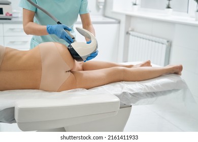 Beauty specialist using non-invasive vela shape technology on buttocks