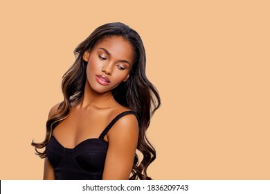 Beauty Styled Portrait Of A Young African - American Woman. Fashion African - American Girl With Curly Hair Posing In The Studio On A Beige Background. Isolated. Studio Shot.                          