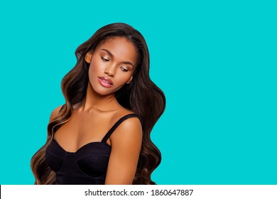 Beauty styled portrait of a young African American woman. makeup. Fashion black girl with curly hair posing in the studio on a  turquoise background. isolated. Studio shot.                          