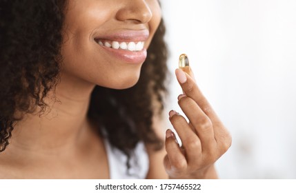 Beauty Supplement. Smiling Black Girl Taking Biotin Vitamin Capsule For Healthy Skin, Cropped Image, Panorama With Copy Space