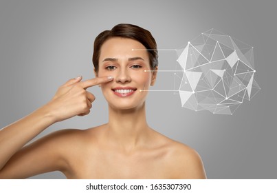 Beauty, Technology And Science Concept - Smiling Beautiful Young Woman Showing Her Face And Pointers With Low Poly Shape Projection Over Grey Background