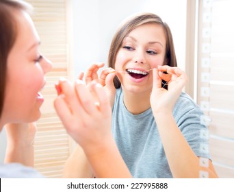 Beauty Teenage Girl Flossing Her Teeth At Home. Pretty Young Woman Using An Interdental Brush Smiling At The Mirror Enjoying Beautiful White Teeth. Healthcare Of Mouth And Dental Floss. Dental Hygiene