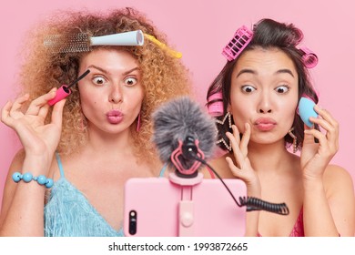 Beauty Tips For Followers. Surprised Women Look At Smartphone Camera Film Live Stream Video Apply Mascara And Foundation Keep Lips Rounded Make Hairstyle Prepare For Special Event. Online Tutorial