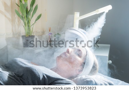 Beauty treatment of face with ozone facial steamer in beauty center. Beaultiful Blonde Girl.