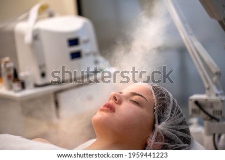 Beauty treatment of face with ozone facial steamer in beauty salon.