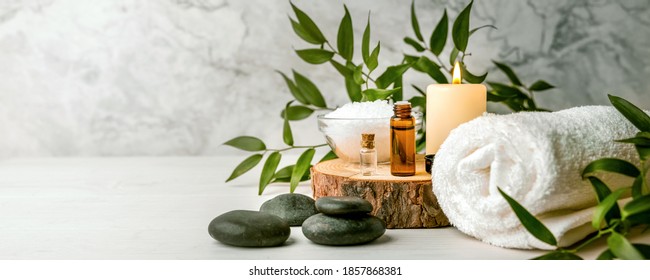 beauty treatment items for spa procedures on white wooden table. massage stones, essential oils and sea salt. copy space - Powered by Shutterstock