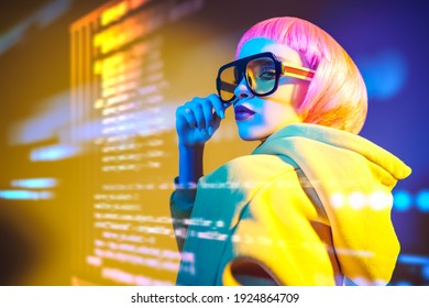 Beauty Trends. Attractive Fashion Model Girl With Bright Makeup And Pink Hair Poses In Modern Sunglasses And Yellow Suit Against The Background Of Holographic Data. Information Technology.