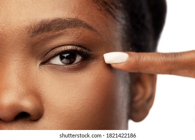 Beauty, Vision And People Concept - Close Up Of Face Of Beautiful Young African American Woman Pointing To Her Eye Over White Background