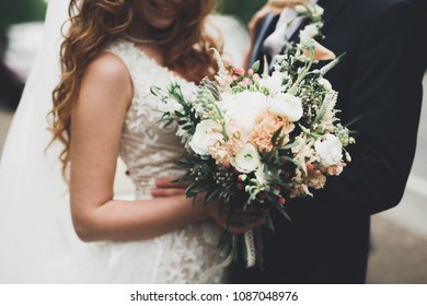 Beauty wedding bouquet with different flowers in hands