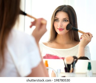 Beauty Woman Applying Makeup. Beautiful Girl Looking In The Mirror And Applying Cosmetic With A Big Brush. Girl Gets Blush On The Cheekbones. Powder, Rouge