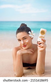 Beauty Woman in Bikini Holding Bottles of Sunscreen in Her Hands. Skin care. A Beautiful Female Applying Sun Cream. Using Sun protection. 