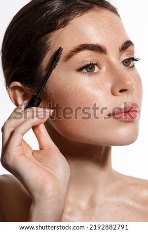 Beauty woman with clear glowing skin, brushing her eyebrows, using brow gel. Concept of skin care and spa