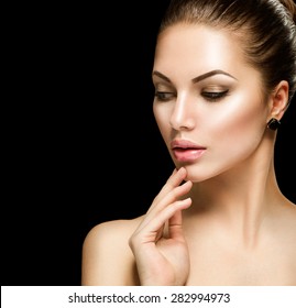 Beauty woman face closeup isolated on black background. Beautiful model girl makeup. Gorgeous sexy brunette lady touching her skin. Perfect make up