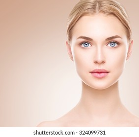 Beauty Woman face Portrait. Beautiful Spa model Girl with Perfect Fresh Clean Skin. Blonde female looking at camera and smiling. Youth and Skin Care Concept. Over beige background