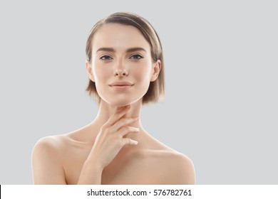 Beauty Woman Face Portrait. Beautiful Model Girl With Perfect Fresh Clean Skin. Blonde Short Hair Youth And Skin Care Concept. Isolated On A Gray Background