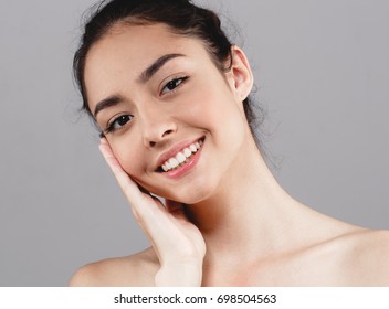Beauty Woman face Portrait. Beautiful model Girl with Perfect Fresh Clean Skin tanned. Healthy teeth smile Youth and Skin Care Concept.