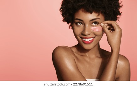 Beauty woman with glowing skin, puts eye patches under her eyes for skincare lifting effect, smiling, standing over pink background. - Powered by Shutterstock