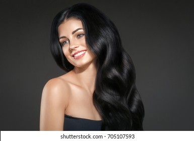 Beauty Woman long black hair. Beautiful Spa model Girl with Perfect Fresh Clean Skin. Brunette woman smiling on black background. Beautiful hairstyle 