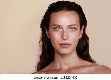 Beauty woman portrait. Beautiful spa model girl with perfect fresh clean skin. Youth and skin care concept. Beige background. Nude makeup