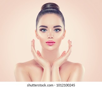 Beauty Woman Portrait. Front View Spa Model Girl Headshot. Pretty Young Woman Touching Her Face. Skin Care.  Youth. Beautiful Fashion Model Girl Face. Perfect Skin. On Beige Background