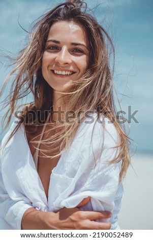 Beauty woman posing in the beach bikini, cute, fashion model, blonde hair, skin tan, wild hair, white dress, kimono, tattoo hand and body, tanning, skin tan, happy face, sea
