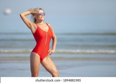 Beauty Woman In Red Swimsuit On The Beach